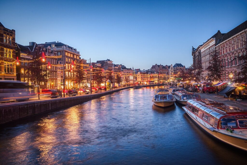 View of the canals in Amsterdam with many boats on the water. 