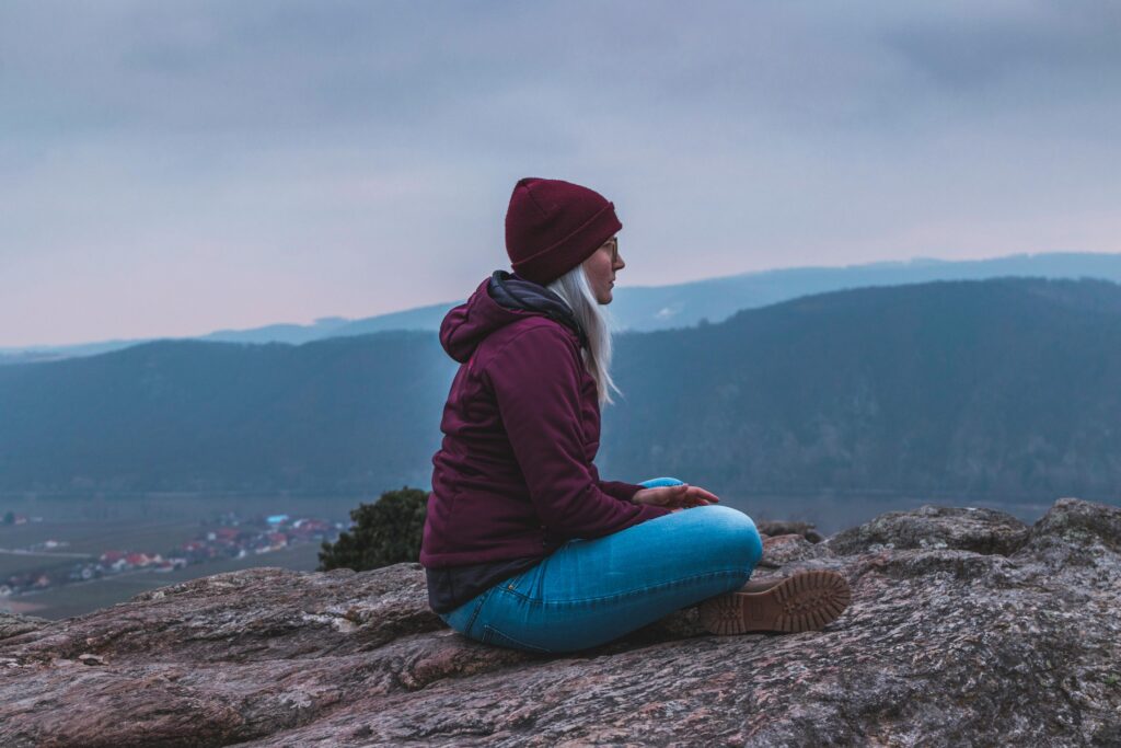 A female traveler chilling at a mountain top.