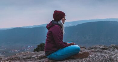 A female traveler chilling at a mountain top.