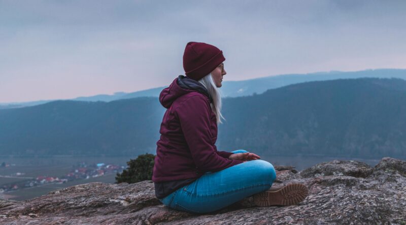 A female traveler chilling at a mountain top.
