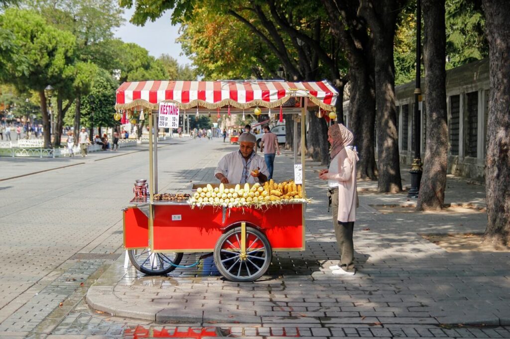 A man selling grilled corn