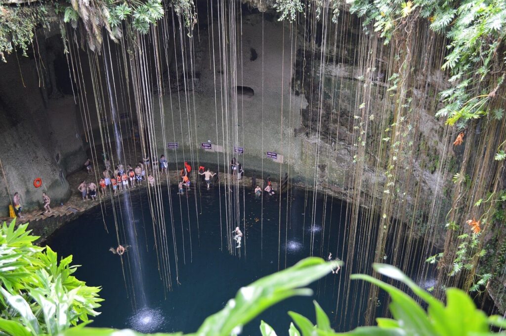 Turquoise cenote pool surrounded by hanging vines at Cenote Oxman, hidden gem in North America