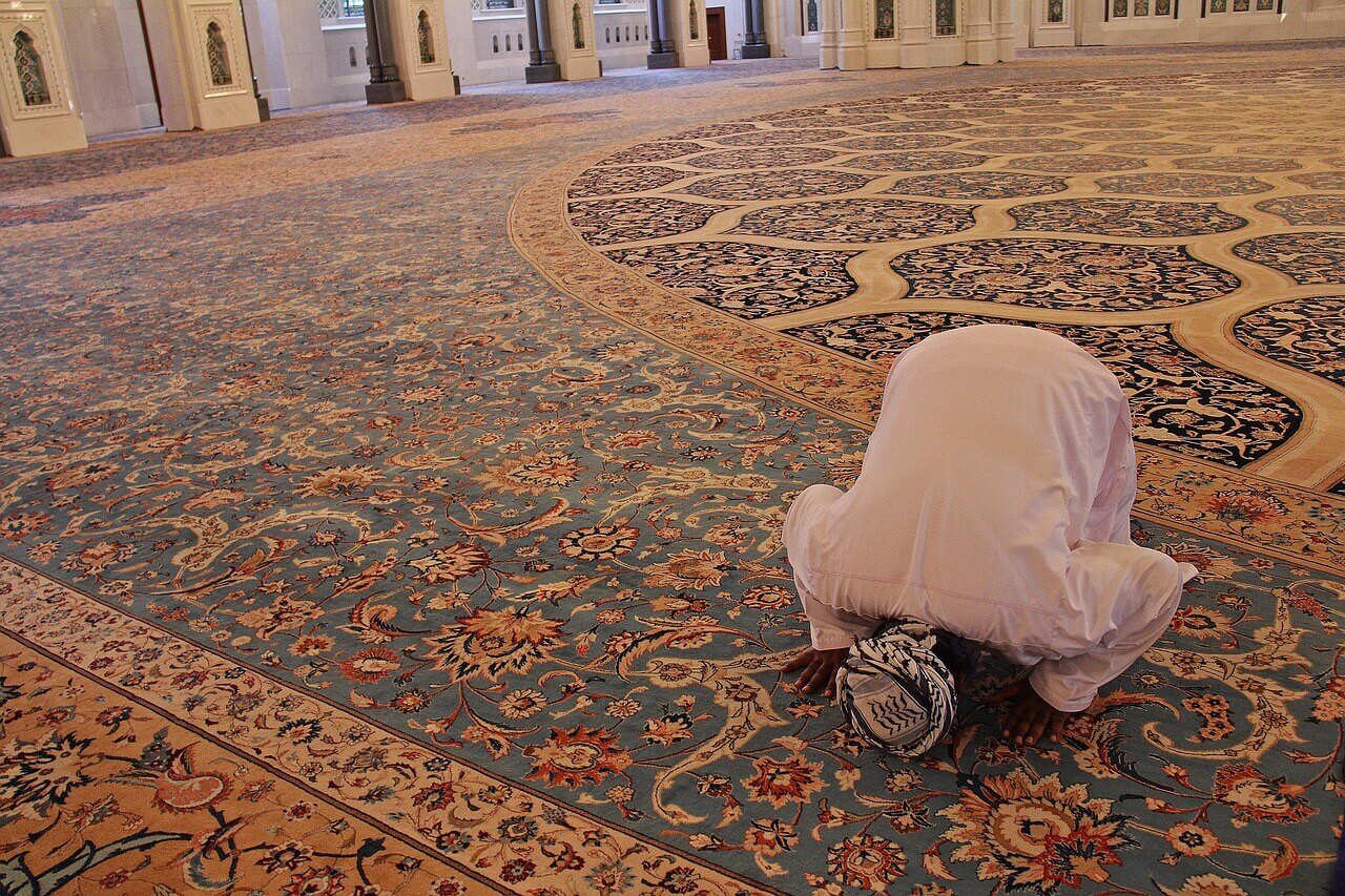 man praying inside mosque 