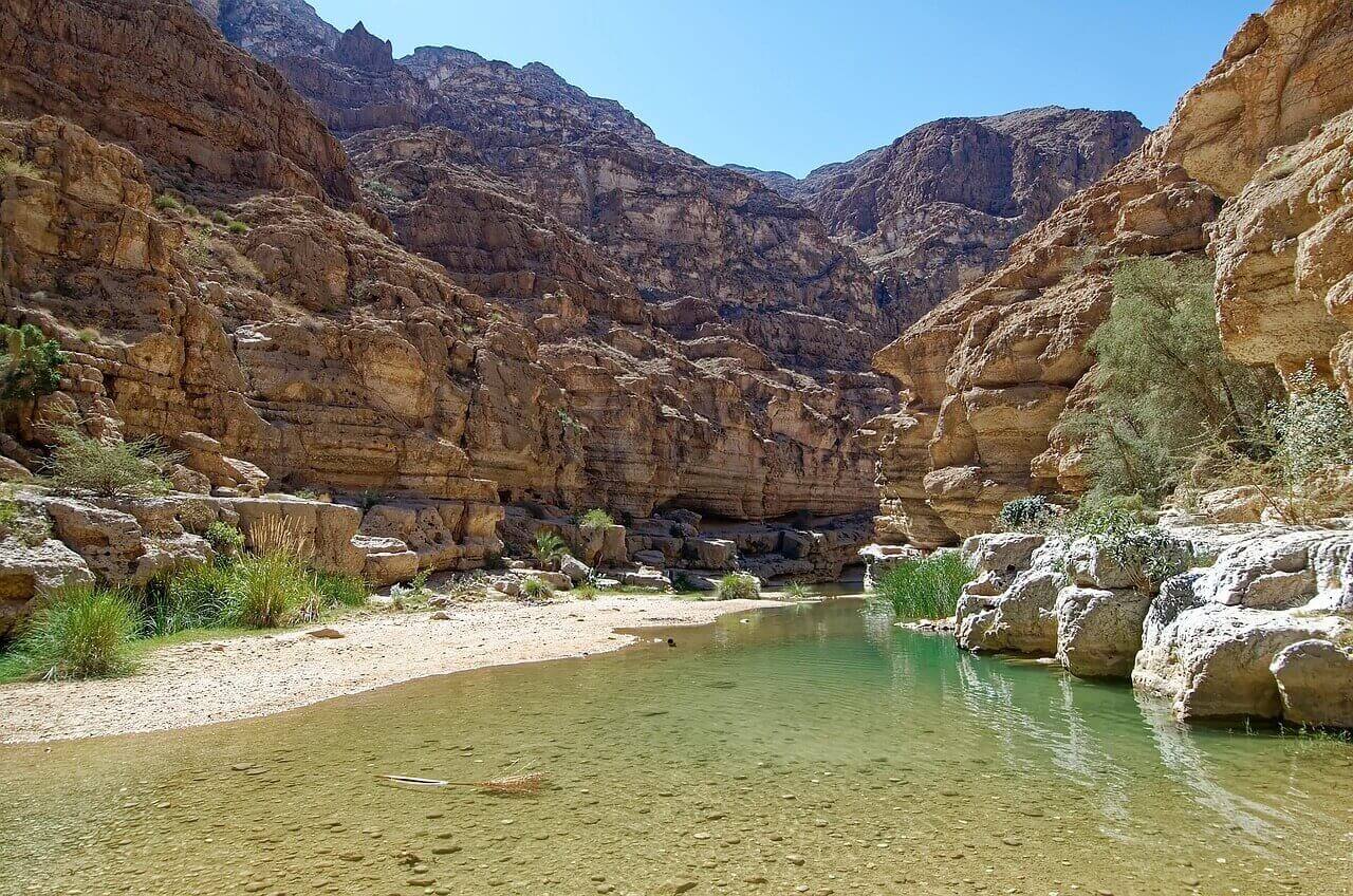 Wadi Shab, clear water surrounded by rock cliffs
