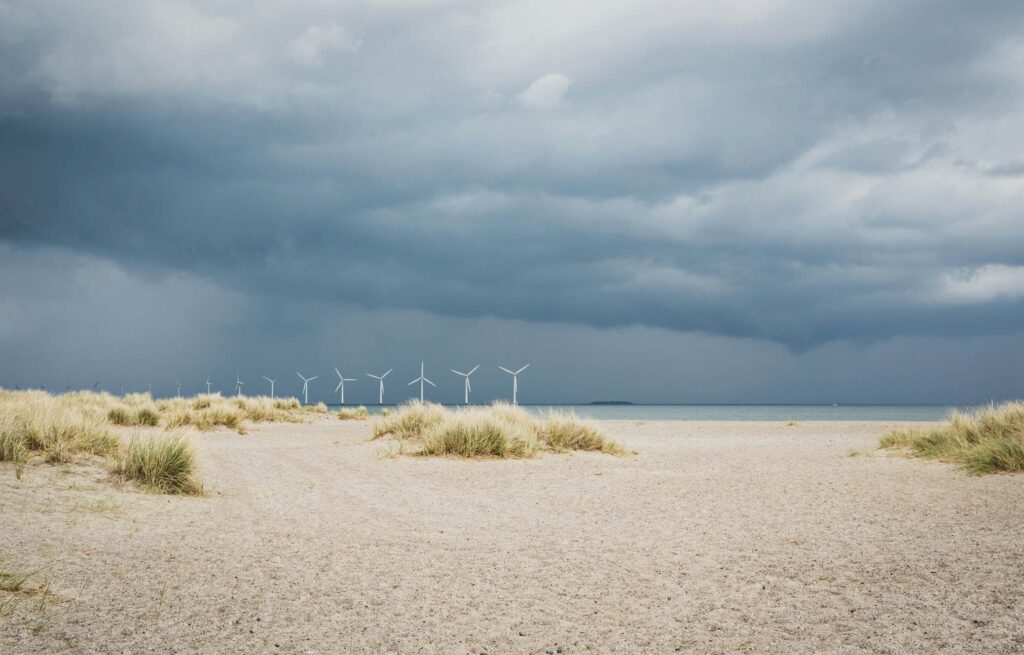 Amager beach park, with windmills seen in the background and sand in the foreground. 
