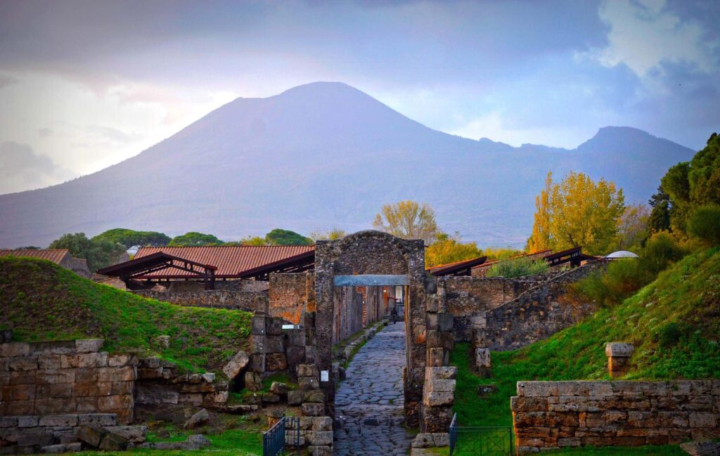 Ancient street and columns in Pompeii with Mount Vesuvius in the background