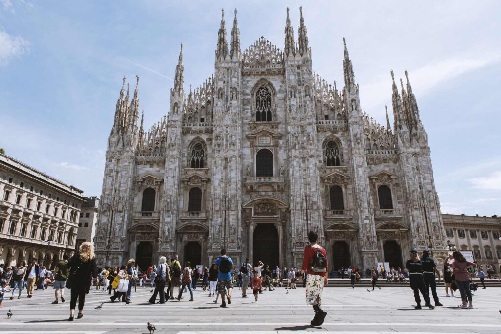 Visitors walking among the marble spires on the rooftop terraces of Milan's Duomo