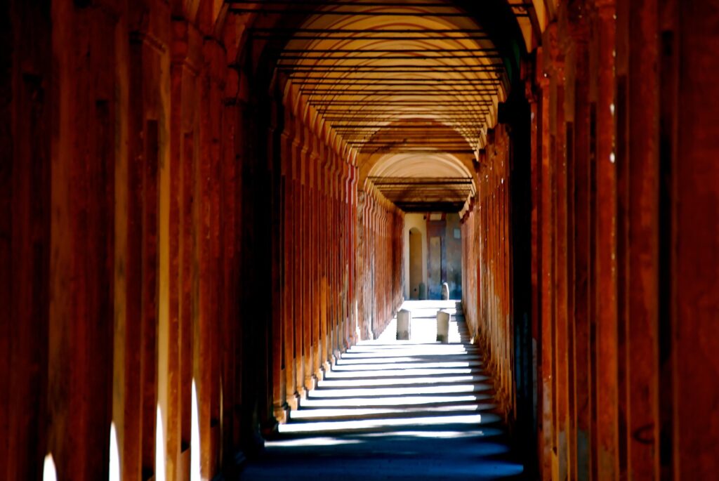 Long arched porticoes along a quiet street in Bologna, Italy